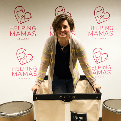 Jamie Lackey in front of a wall of Helping Mamas logos